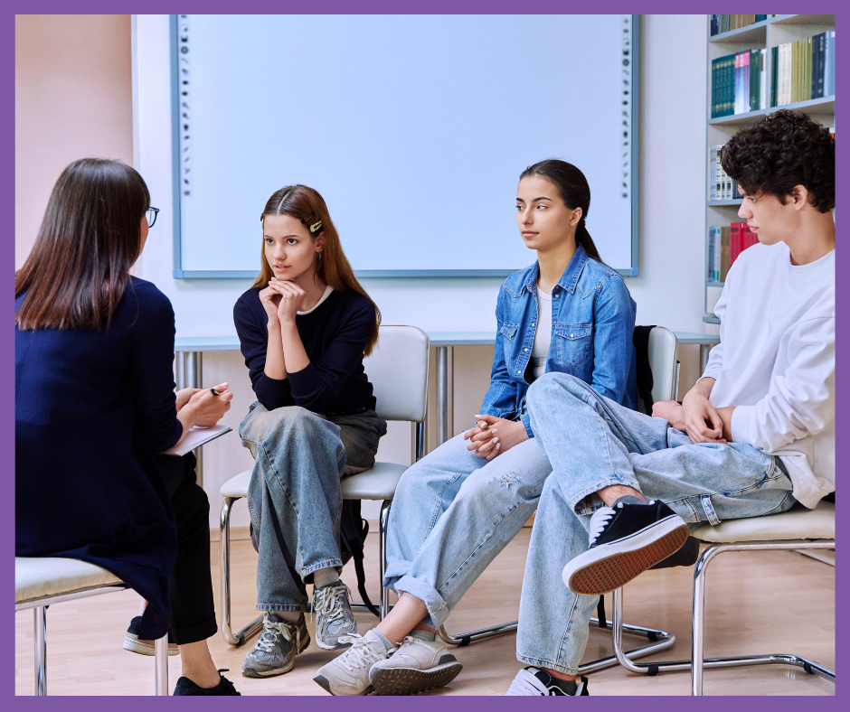 Educadora hablando con un grupo de adolescentes en un taller de educación sexual integral, con materiales didácticos y ambiente de confianza.